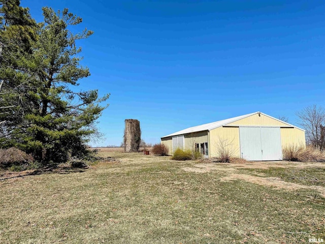 view of yard featuring an outbuilding, a garage, and a pole building