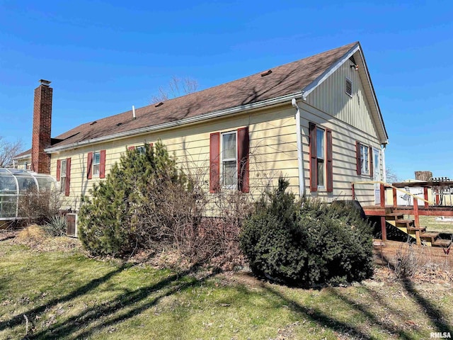 view of home's exterior featuring a lawn and a chimney