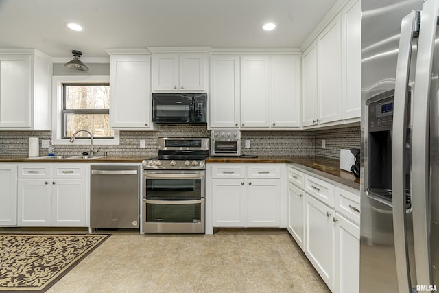 kitchen featuring recessed lighting, tasteful backsplash, appliances with stainless steel finishes, and white cabinetry