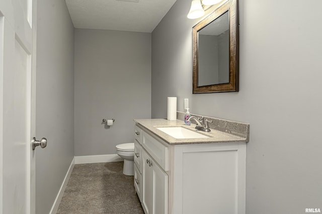 half bathroom with vanity, toilet, and baseboards