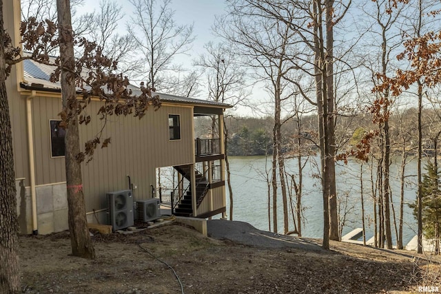 exterior space featuring stairway, ac unit, and a water view