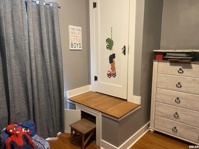 interior space with wood finished floors and baseboards