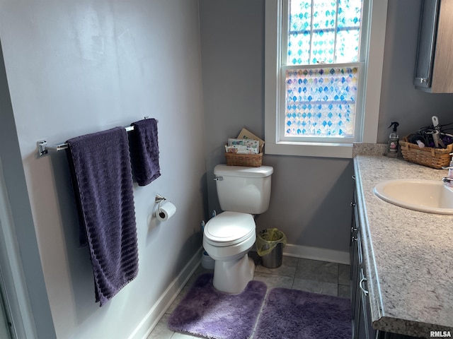 bathroom featuring tile patterned floors, baseboards, toilet, and vanity