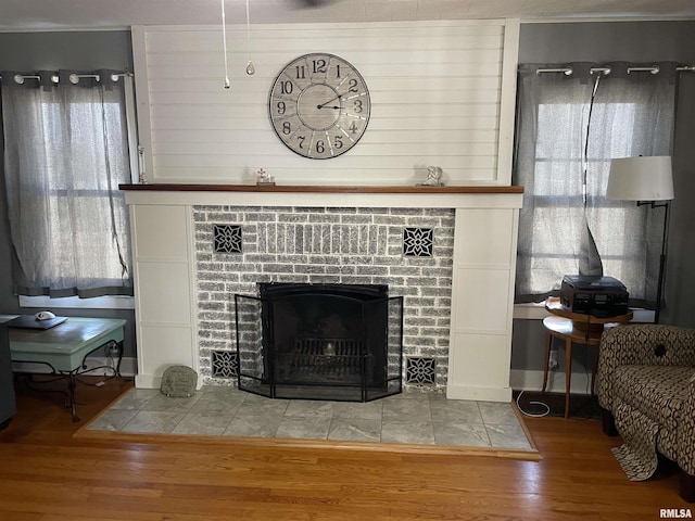 details with a brick fireplace and wood finished floors