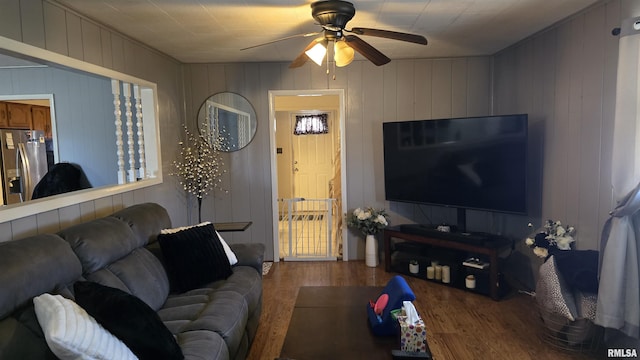 living area with a ceiling fan and wood finished floors