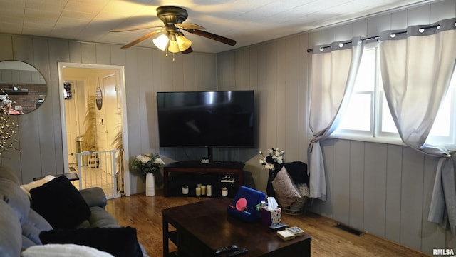 living room featuring visible vents, a ceiling fan, and wood finished floors