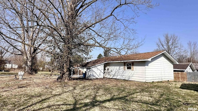 view of side of property with fence and a lawn