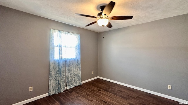 empty room with ceiling fan, baseboards, dark wood-style flooring, and a textured ceiling