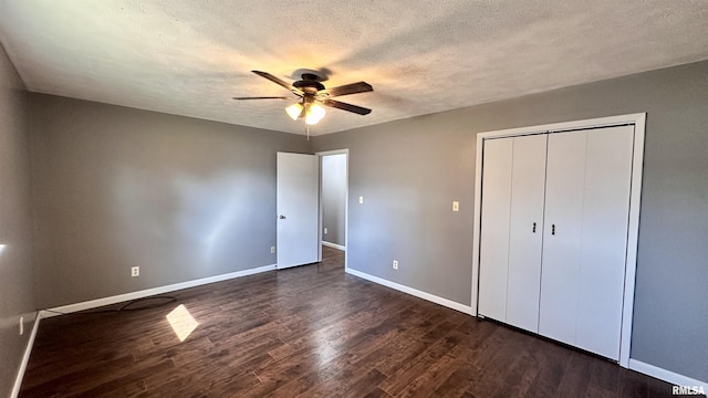 unfurnished bedroom featuring baseboards, dark wood-style flooring, ceiling fan, a closet, and a textured ceiling