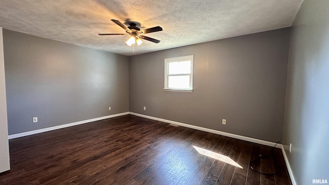 spare room with baseboards, dark wood-type flooring, ceiling fan, and a textured ceiling