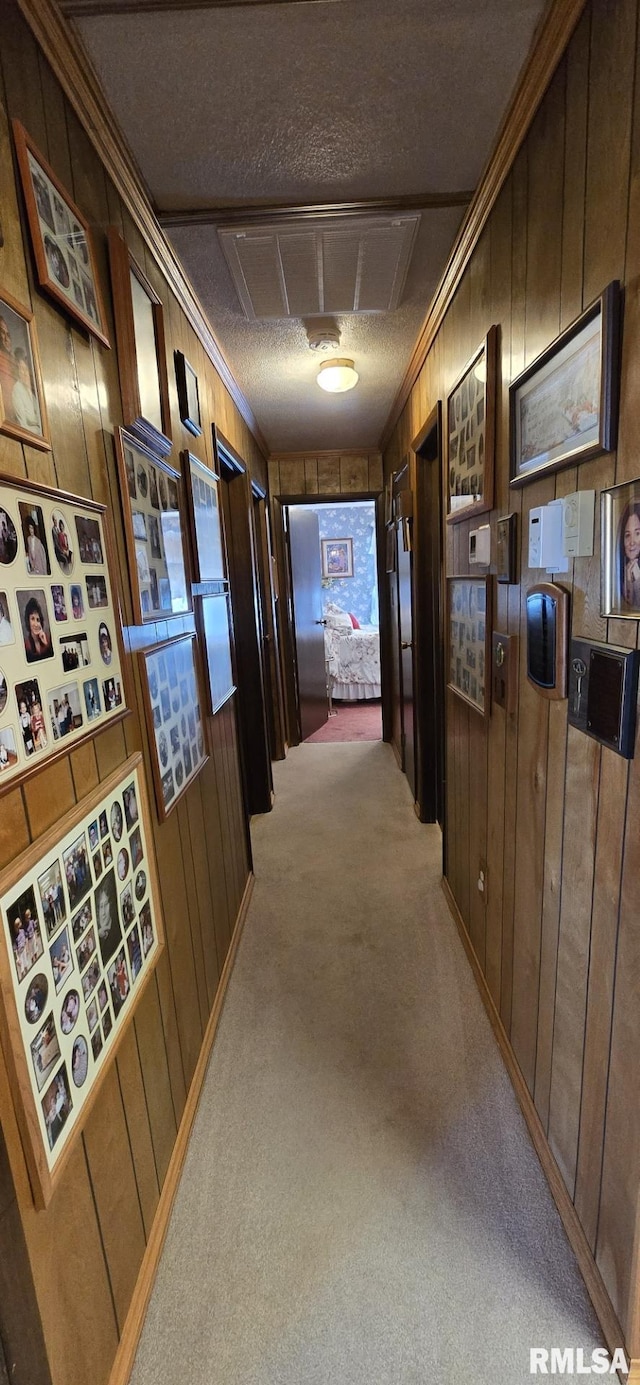 hall featuring wooden walls, visible vents, and carpet