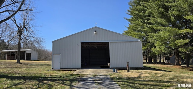 view of pole building featuring a lawn and driveway