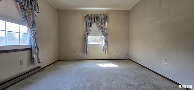 spare room with crown molding, baseboards, a baseboard heating unit, and carpet