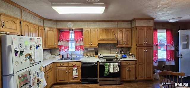 kitchen with custom range hood, black dishwasher, electric stove, freestanding refrigerator, and a sink