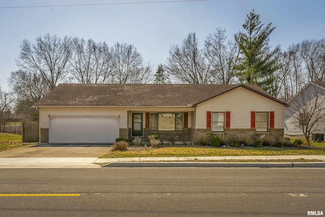 single story home with driveway, brick siding, and an attached garage