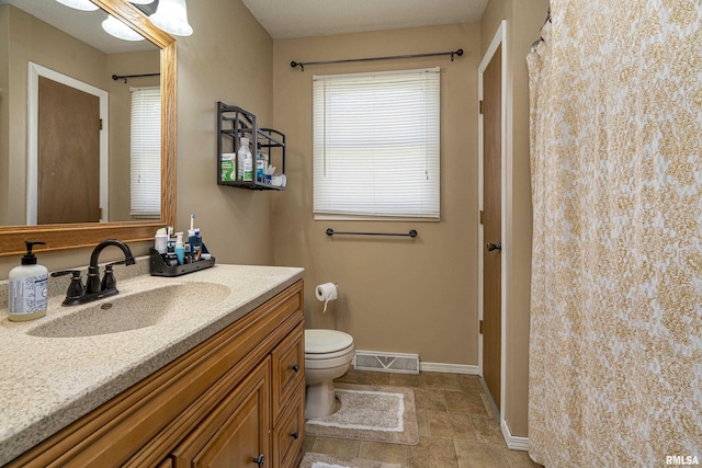 full bathroom with vanity, a shower with curtain, baseboards, visible vents, and toilet