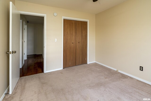 unfurnished bedroom featuring a closet, baseboards, and carpet floors