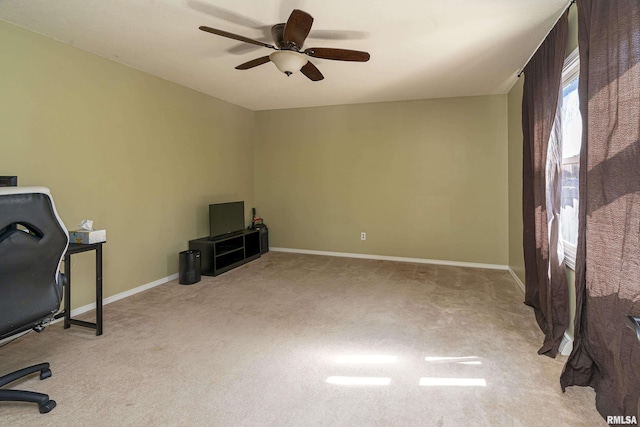 office space with baseboards, carpet, and a ceiling fan