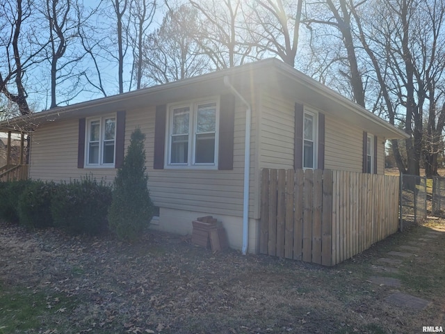 view of side of property with crawl space and fence