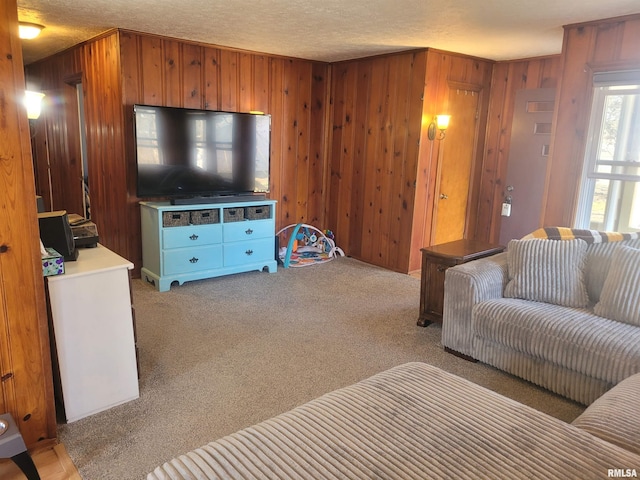 living area with a textured ceiling, wood walls, and light carpet