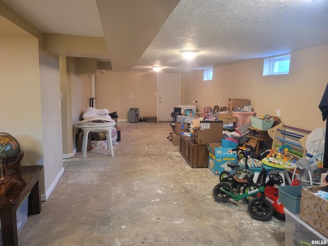 basement featuring baseboards and a textured ceiling