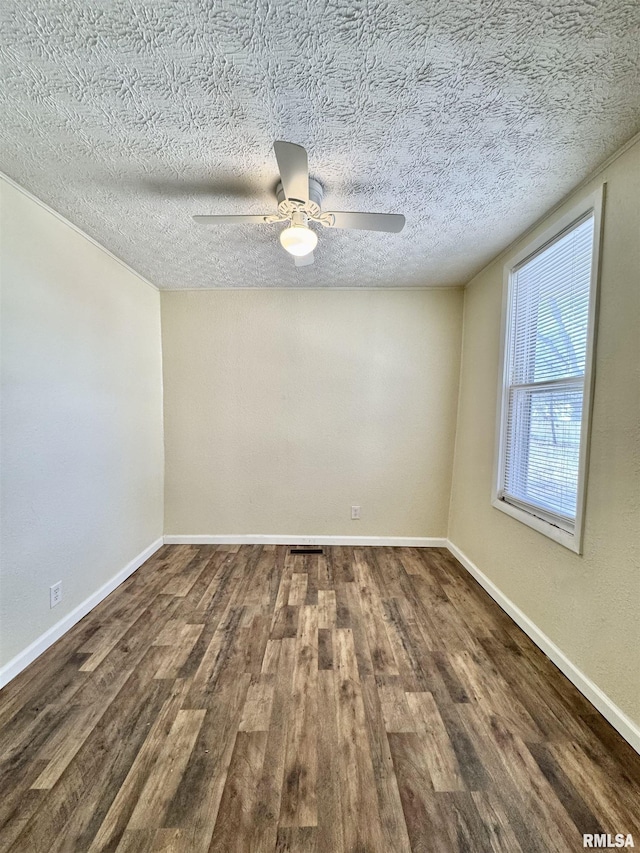 empty room featuring ceiling fan, a textured ceiling, baseboards, and wood finished floors