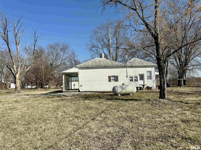 rear view of property with a yard and a chimney