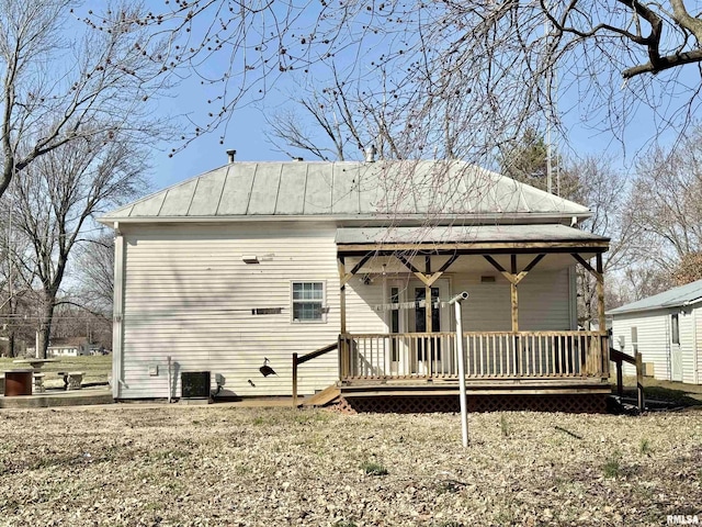 rear view of property with a standing seam roof, central AC, and metal roof