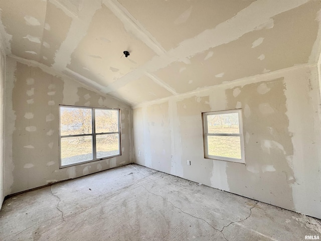 unfurnished room with lofted ceiling and plenty of natural light