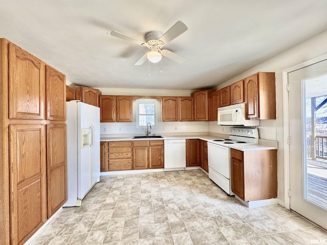 kitchen with white appliances, light countertops, brown cabinets, and a sink