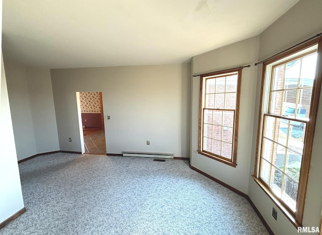 unfurnished room with a baseboard heating unit, baseboards, and carpet flooring