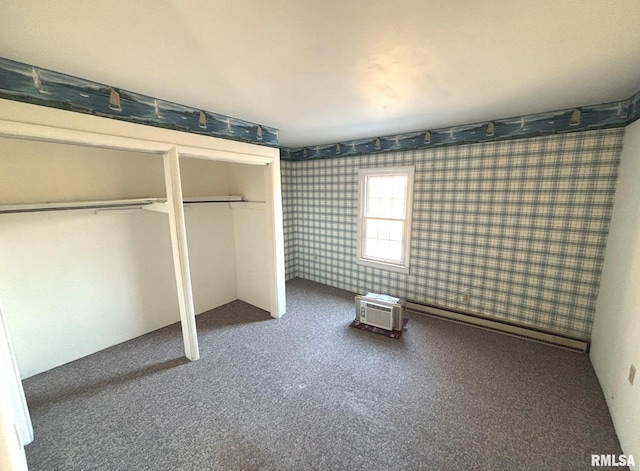 unfurnished bedroom featuring wallpapered walls, an AC wall unit, carpet flooring, and a baseboard heating unit