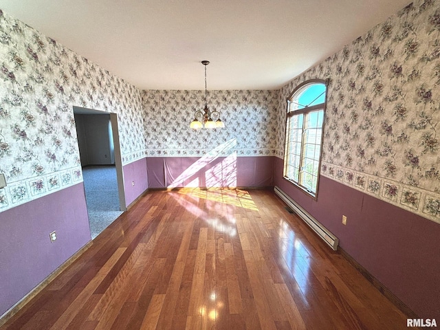 unfurnished dining area with a baseboard radiator, wood finished floors, a wainscoted wall, and wallpapered walls