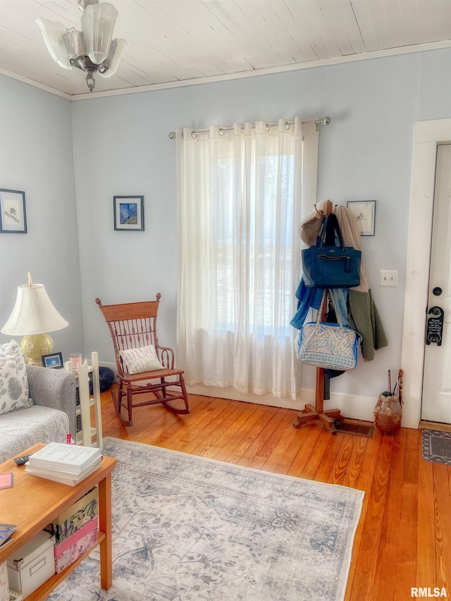 living area with crown molding and wood finished floors