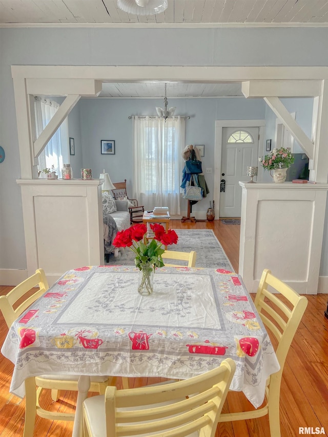 dining room featuring an inviting chandelier, wood finished floors, and ornamental molding