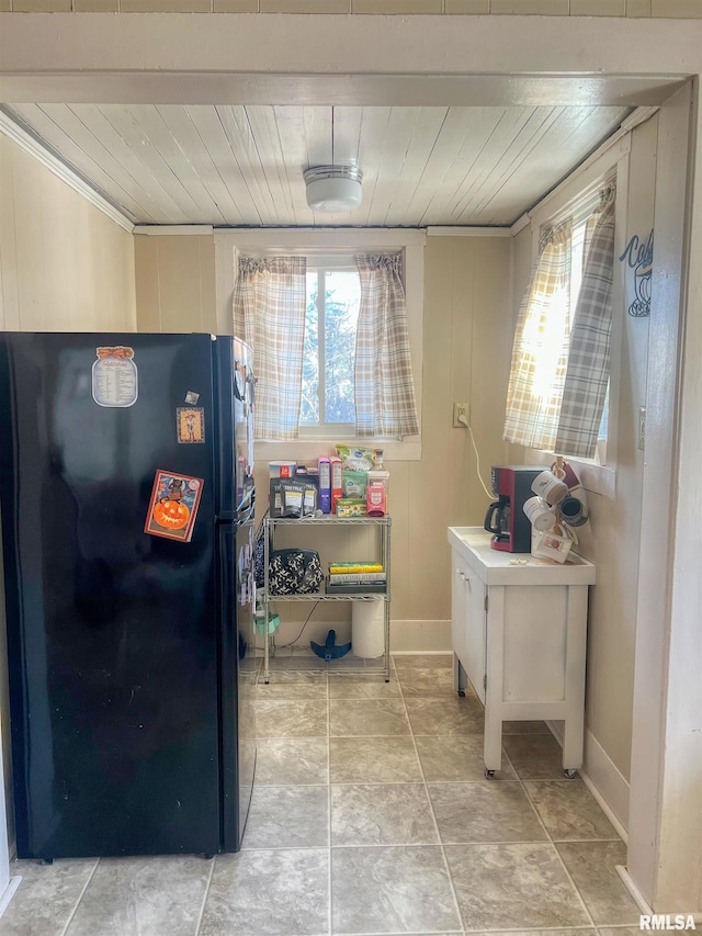 kitchen featuring wood ceiling, freestanding refrigerator, and ornamental molding