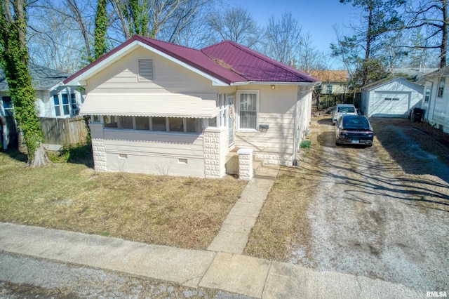 view of front of property with driveway, a detached garage, fence, an outdoor structure, and crawl space