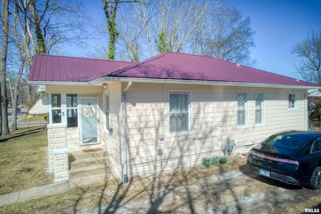 view of front facade with entry steps and metal roof