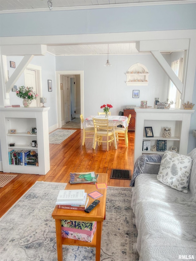 living area featuring visible vents and wood finished floors