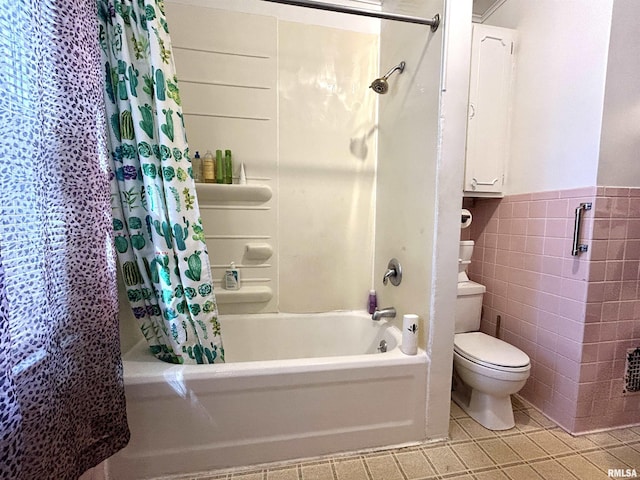 bathroom featuring tile patterned floors, toilet, tile walls, wainscoting, and shower / bath combination with curtain