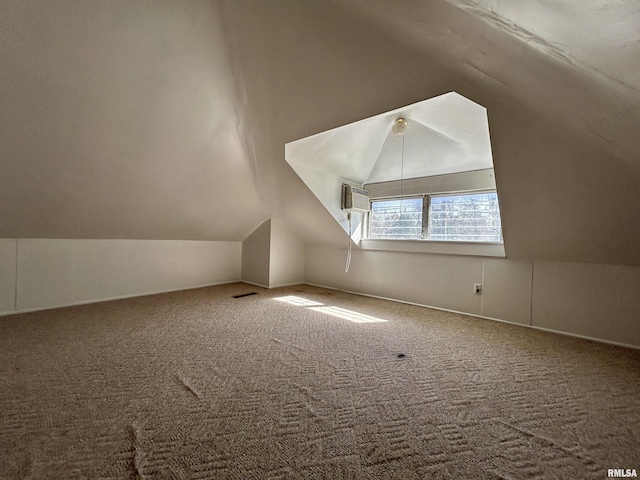 additional living space featuring lofted ceiling and carpet flooring