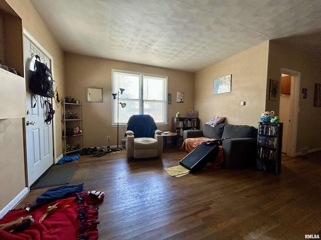 interior space with baseboards, wood-type flooring, and a textured ceiling