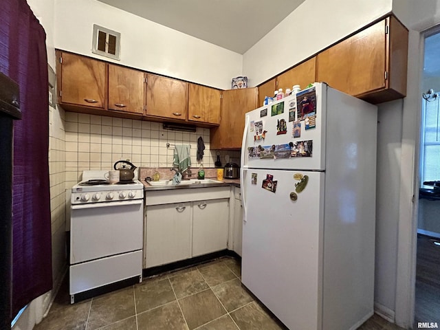 kitchen with white appliances, visible vents, light countertops, brown cabinets, and backsplash