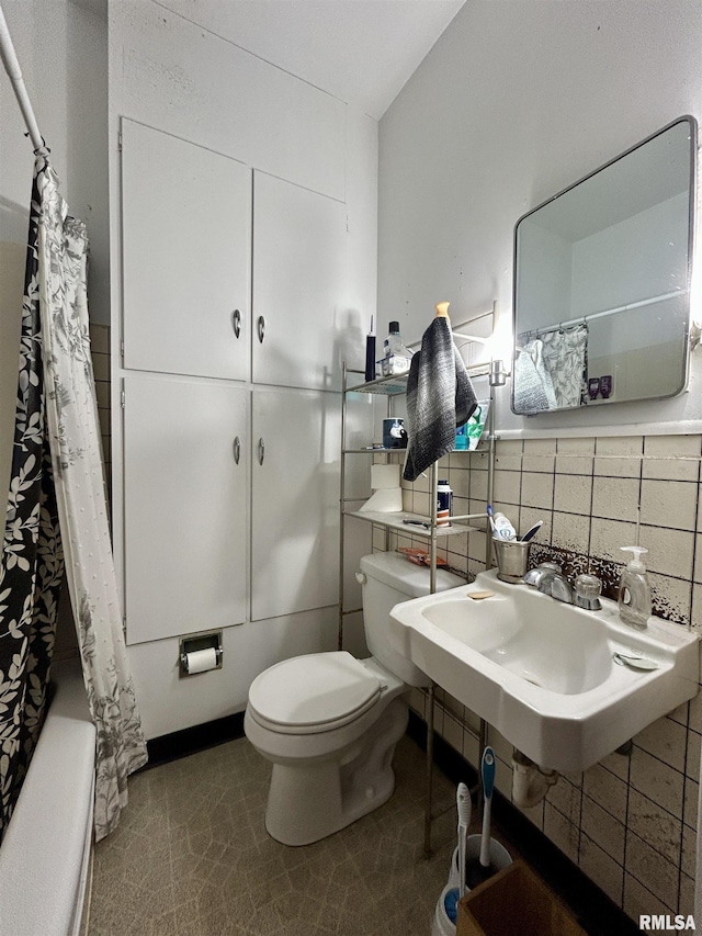 bathroom featuring backsplash, toilet, and a sink