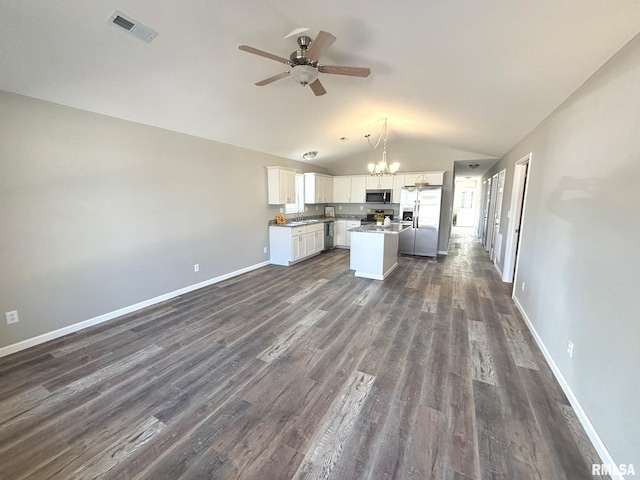 kitchen featuring visible vents, lofted ceiling, stainless steel appliances, ceiling fan with notable chandelier, and open floor plan