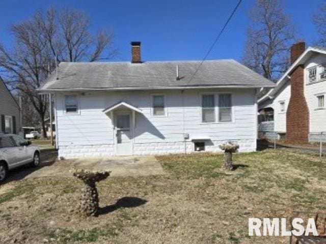 back of house with a chimney