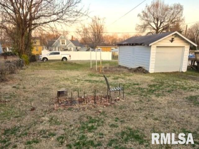 yard at dusk with an outdoor structure and a garage