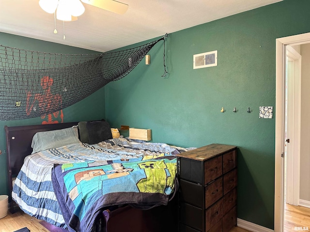 bedroom with baseboards, a ceiling fan, lofted ceiling, and wood finished floors