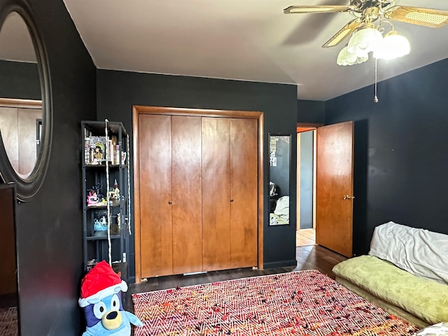 bedroom with a closet, wood finished floors, and a ceiling fan