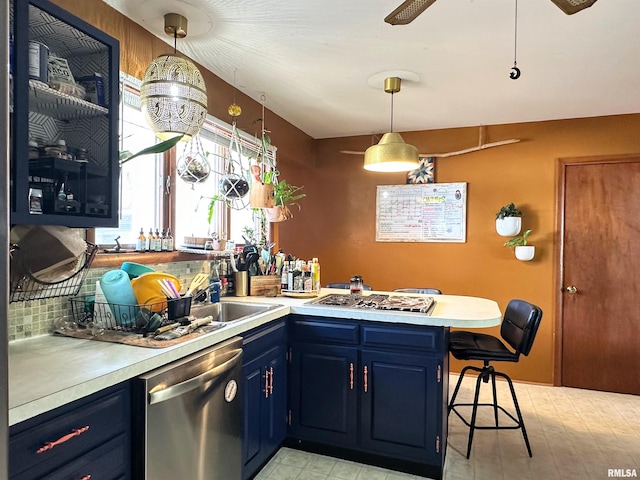 kitchen featuring blue cabinets, a breakfast bar, appliances with stainless steel finishes, a peninsula, and light countertops